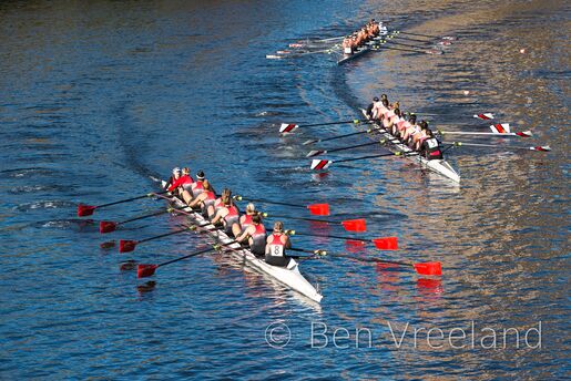 Three collegiate boats round a bend in the the Charles River during the Head of the Charles Regatta