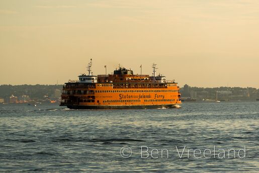An orange Staten Island Ferry at sunset in New York City